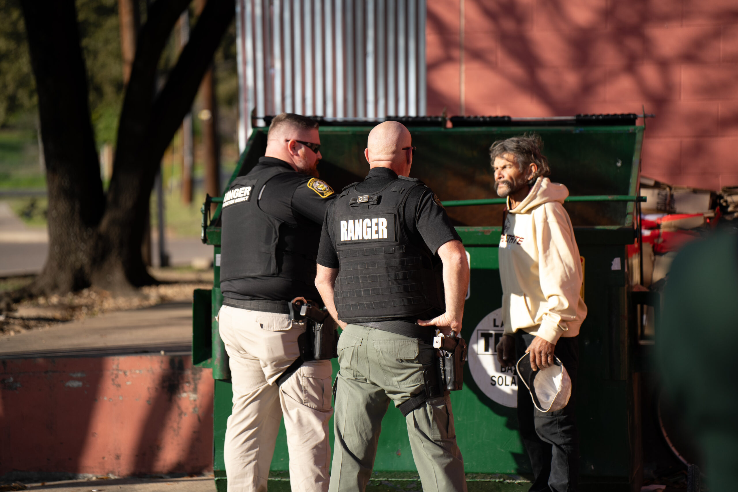 Two Ranger Protection Agency officers communicating with a person during a property contact