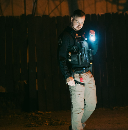 Ranger security officer conducting a nighttime patrol with a flashlight