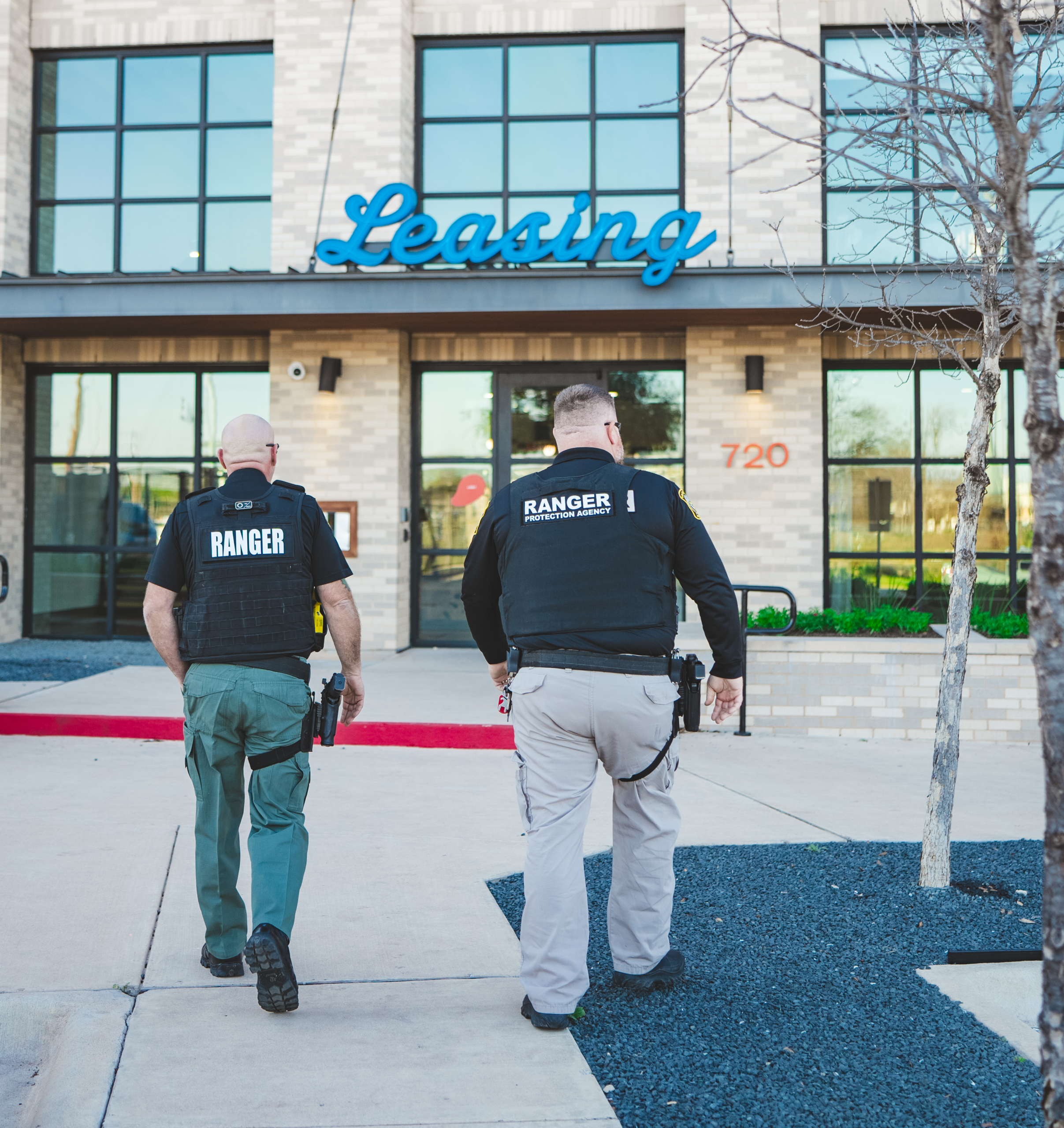 Two Ranger security officers walking toward a leasing office