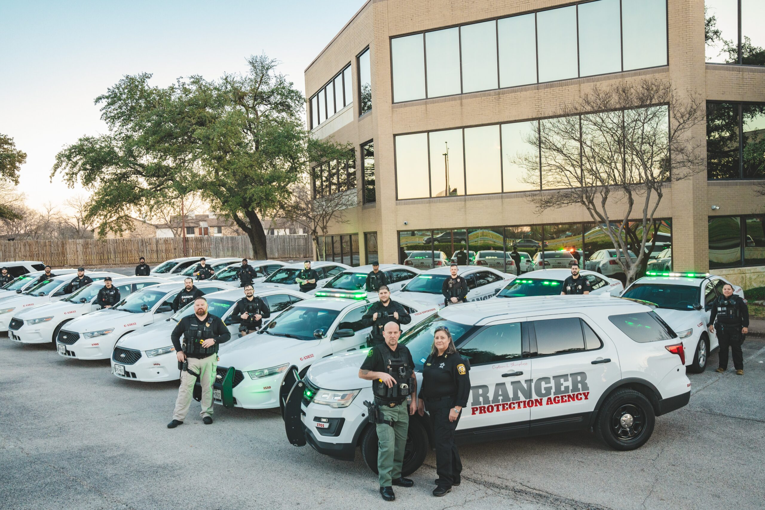 Ranger Protection Agency uniformed security officers standing beside marked security patrol vehicles in Austin Texas